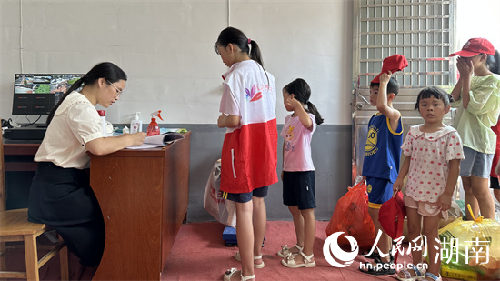 小朋友们将收集的垃圾交给工作人员称重登记。吴茜薇摄