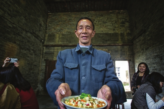 3月26日,平江县新港村,当地村民邀请品尝当地特色的“平江十大碗”。图/记者张迪