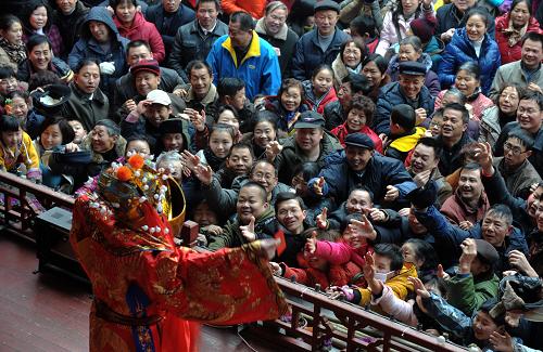 1月25日,在长沙火宫殿迎春庙会上,观众与京剧《跳财神》的演员互动。当日是大年初三,长沙市天气晴好,市内各大公园、景点、商业街区迎来春节长假客流高峰。新华社记者 龙弘涛 摄