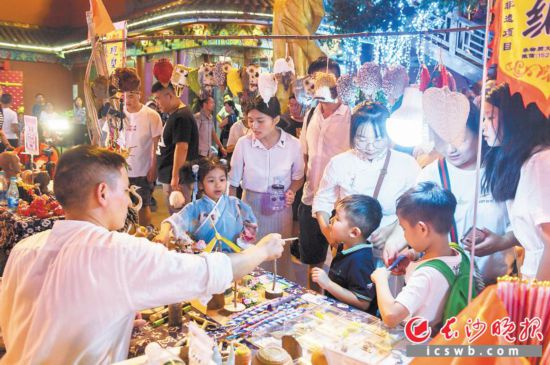 →火宫殿里,游客们正在挑选非遗小物品。