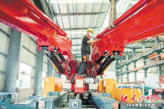 长沙正从“制造之城”向“智造之城”转型升级。图为五新隧装生产车间内 ,工人和机器人协同生产。长沙晚报全媒体记者 王志伟 摄